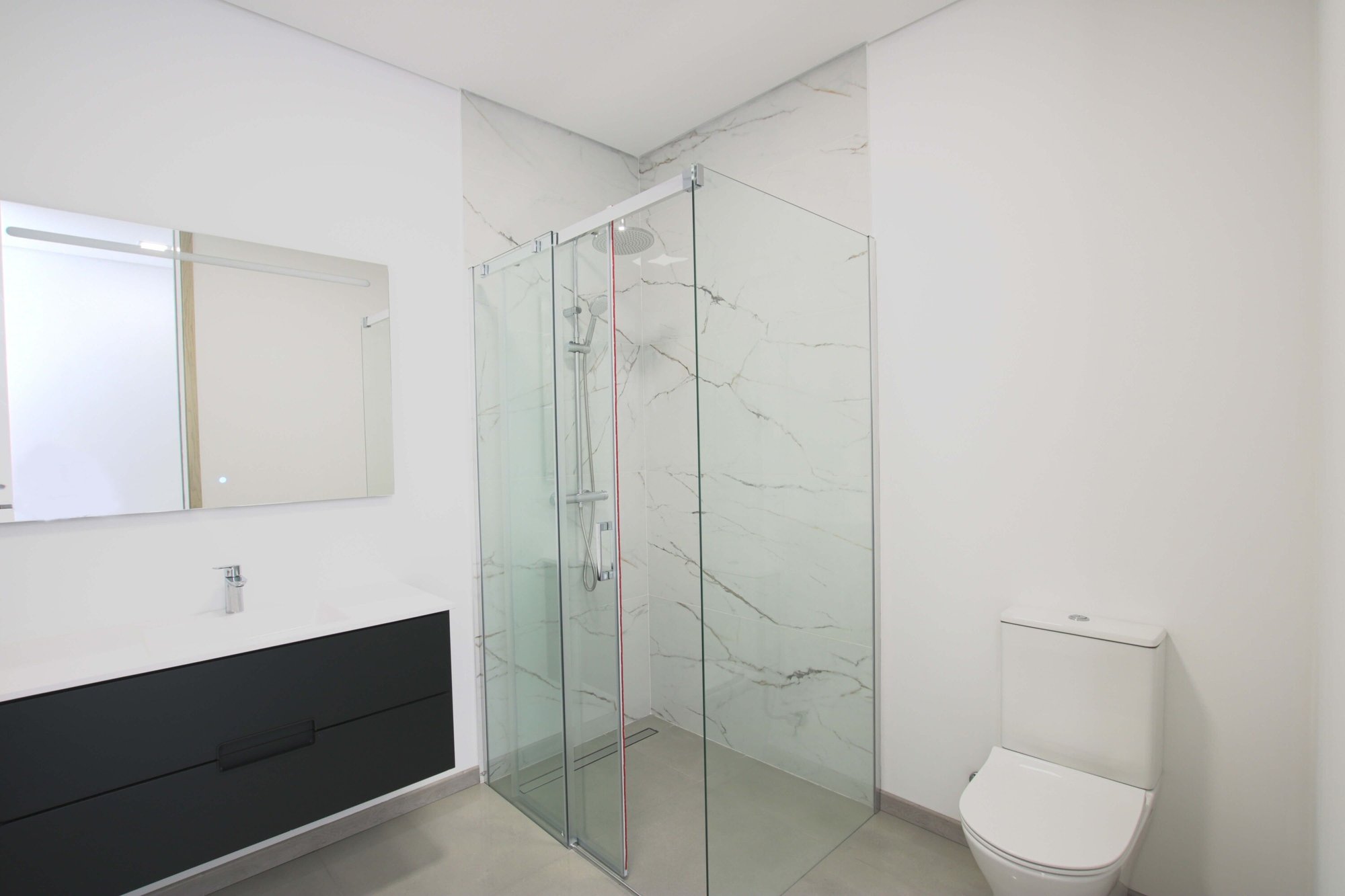 Bathroom with shower, toilet seat, hand basin and mirror 