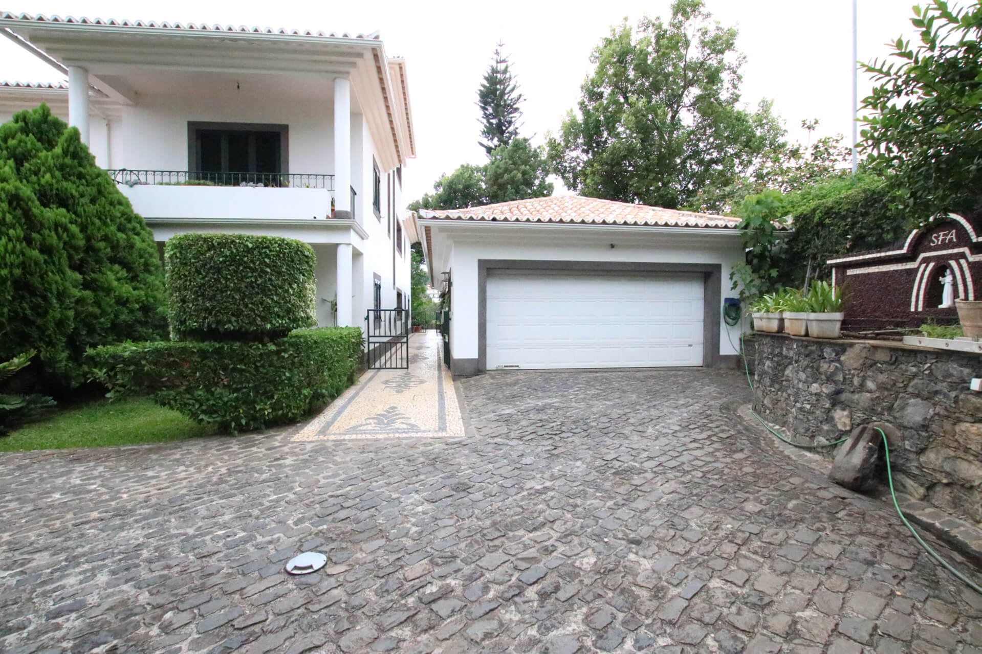 The front facade of the house and it's garage