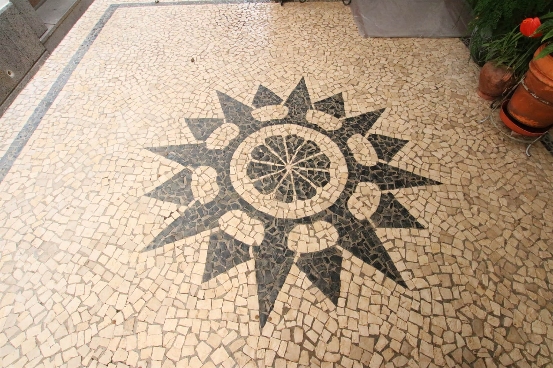 A feature of a section of the house in which there is a geometric shape mosaic on the floor